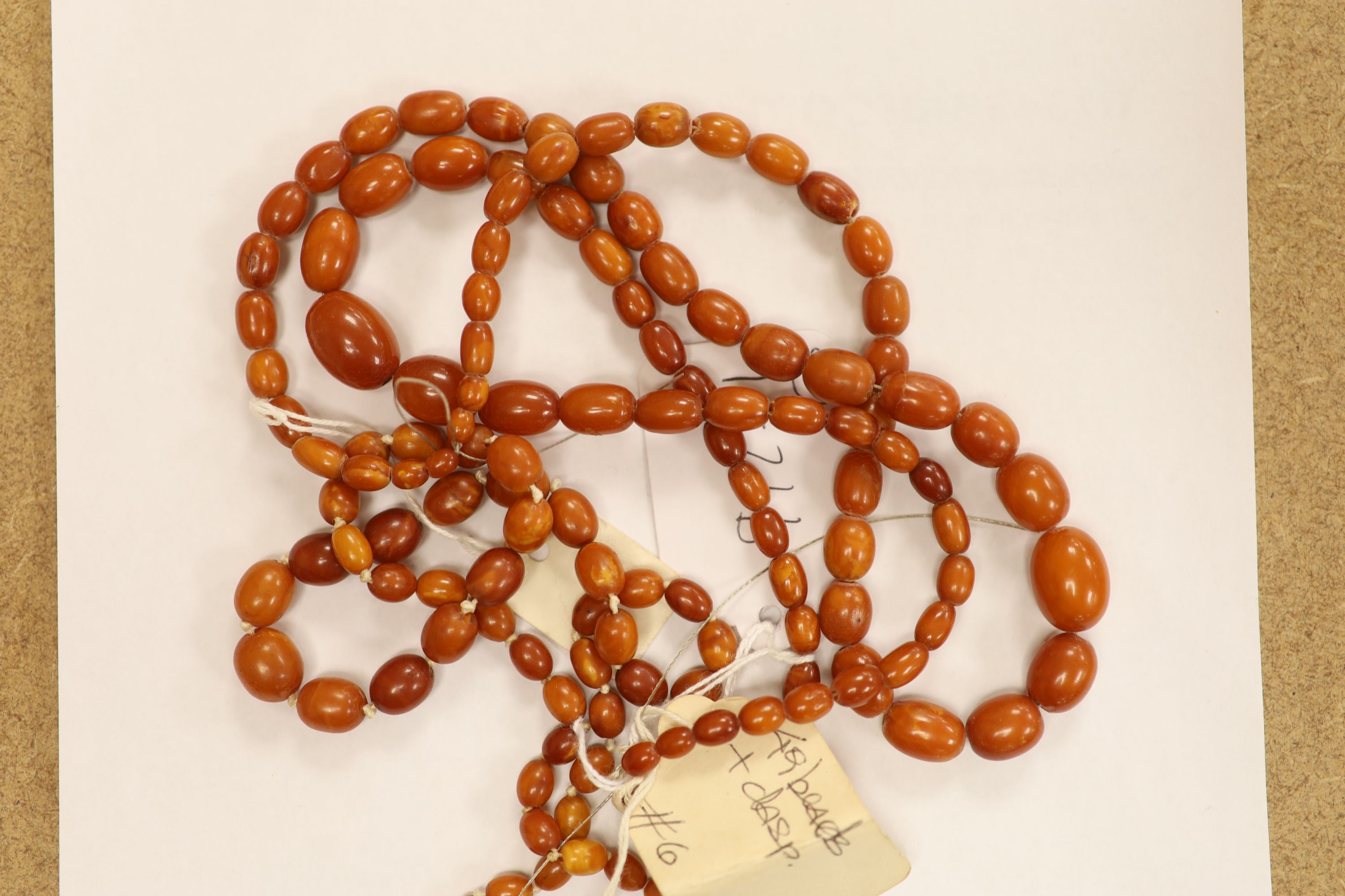 Nine assorted single strand amber bead necklaces, longest approximately 46cm, gross weight 173 grams and one simulated amber bead necklace.